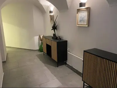 a hallway with a cabinet and a tile floor at Art apartment Kranj in Kranj