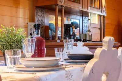 a table with plates and glasses on top of it at Chalet Guapa in Bohinj