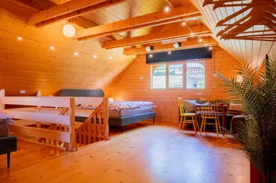 a room with a bed and a table and chairs at Chalet Guapa in Bohinj