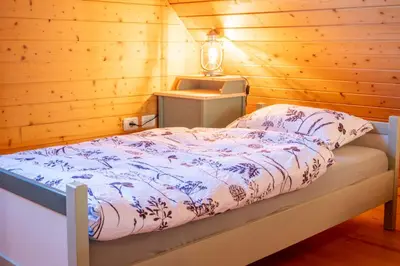 a bedroom with a bed in a wooden room at Chalet Guapa in Bohinj