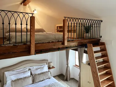 a bedroom with a loft bed and a staircase at Prosciutto Kingdom - Kraljestvo pršuta by Pršutarna Ščuka in Štanjel
