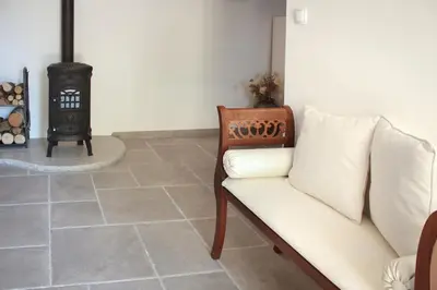 a living room with a couch and a stove at Prosciutto Kingdom - Kraljestvo pršuta by Pršutarna Ščuka in Štanjel