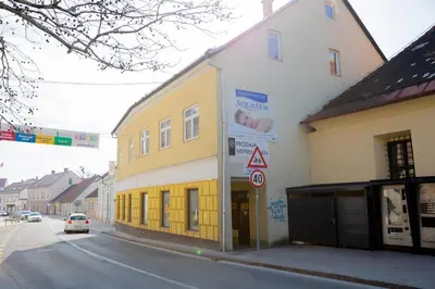 a yellow and white building on the side of a street at Apartma Pri Kosu in Slovenska Bistrica