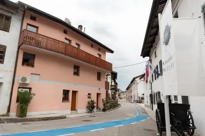 a street in a town with a pink building at Apartma Oleander in Kobarid