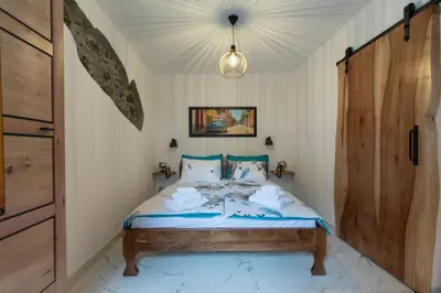 a bedroom with a bed and a wooden door at Apartma Oleander in Kobarid