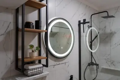 a bathroom with a round mirror and a shower at Apartma Oleander in Kobarid