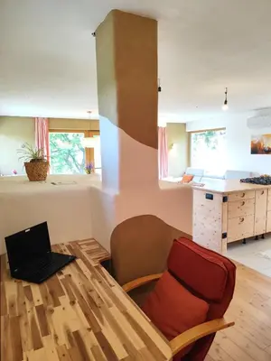 a living room with a table with a laptop on it at Naravna lesena hiša v naravi z lastnim vrtom in Ig