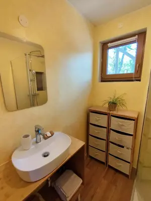 a bathroom with a sink and a mirror at Naravna lesena hiša v naravi z lastnim vrtom in Ig