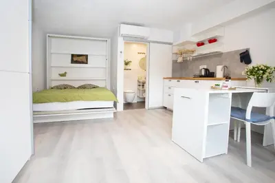 a kitchen and a bedroom with a bed and a desk at Apartment Studio Green in Ljubljana