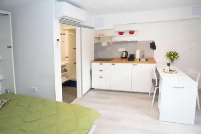 a small kitchen with white cabinets and a table at Apartment Studio Green in Ljubljana