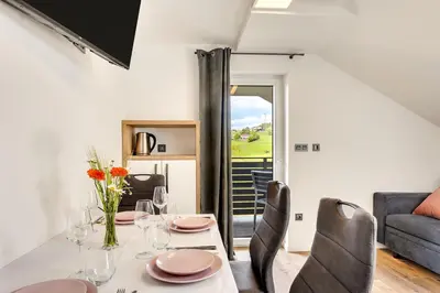 a dining room with a table and chairs at Apartmaji Kunej pod Gradom with sauna in Podsreda