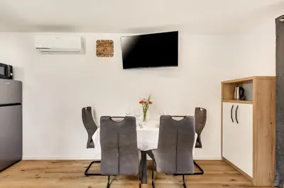 a dining room with a table and two chairs at Apartmaji Kunej pod Gradom with sauna in Podsreda