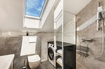 a bathroom with a toilet and a sink and a window at Apartmaji Kunej pod Gradom with sauna in Podsreda