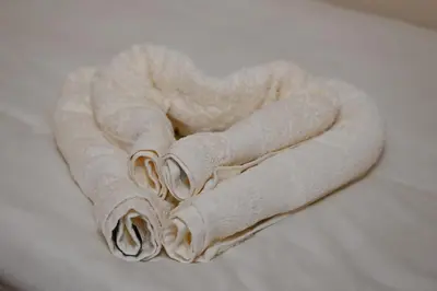 a pile of rolled towels sitting on a bed at Sobe in apartma Portus in Rakek