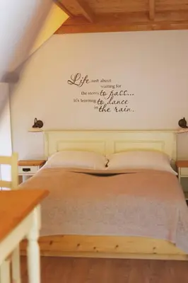 a bedroom with a bed with writing on the wall at Herbal Glamping Resort Ljubno in Ljubno