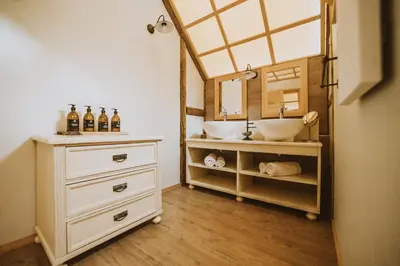 a bathroom with two sinks and a mirror at Herbal Glamping Resort Ljubno in Ljubno