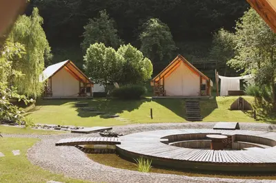 a group of tents in a garden with a circular patio at Herbal Glamping Resort Ljubno in Ljubno