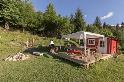 a red cabin with a white canopy in the grass at Relax Room Bohinjska Bistrica in Bohinj