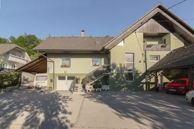 a large yellow house with a staircase in front of it at Relax Room Bohinjska Bistrica in Bohinj