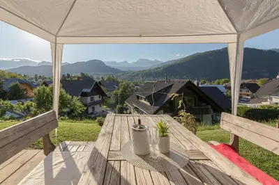 a wooden table on a deck with a white tent at Relax Room Bohinjska Bistrica in Bohinj