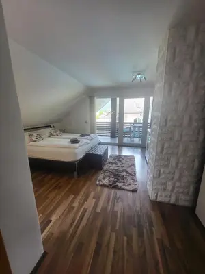a room with a bed and a wooden floor at Relax Room Bohinjska Bistrica in Bohinj