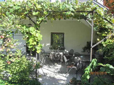 a patio with a table and chairs under a pergola at Apartma Lovriž in Kobarid