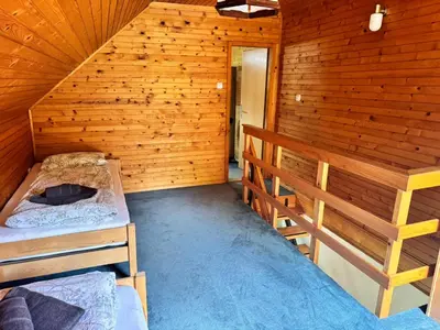 a room with two bunk beds in a wooden cabin at Hiša Jelka in Kranjska Gora