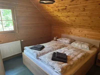 two beds in a room with wooden walls at Hiša Jelka in Kranjska Gora
