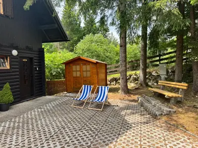 two chairs sitting on a patio next to a shed at Hiša Jelka in Kranjska Gora