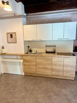 a kitchen with white cabinets and a sink at Historic studio apartment beneath the Ljubljana castle in the old city centre in Ljubljana