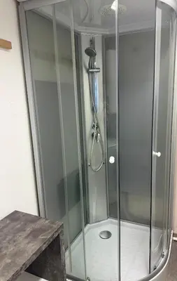 a shower with a glass door in a bathroom at Historic studio apartment beneath the Ljubljana castle in the old city centre in Ljubljana