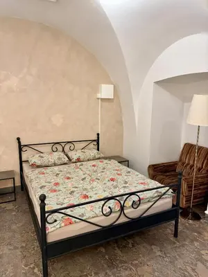 a bedroom with a bed and a chair at Historic studio apartment beneath the Ljubljana castle in the old city centre in Ljubljana
