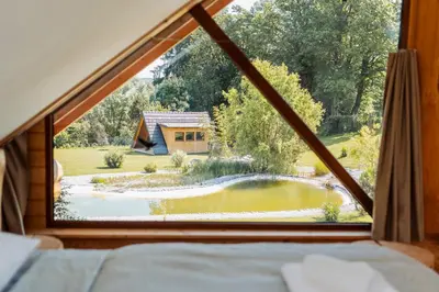 a view from a bedroom window with a view of a garden at Log Garden Estate in Dobrova