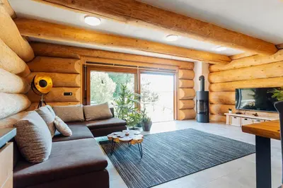 a living room with a couch and a tv at Log Garden Estate in Dobrova