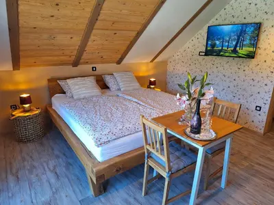 a bedroom with a bed and a table with flowers on it at Škedenj pri Vili Trate in Križevci pri Ljutomeru