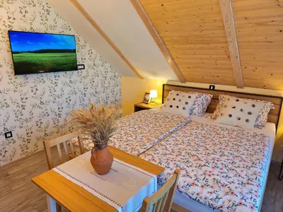 a bedroom with a bed and a table with a vase on it at Škedenj pri Vili Trate in Križevci pri Ljutomeru