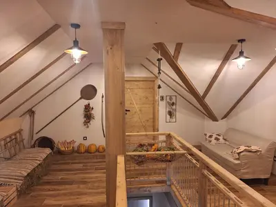 a living room with wooden ceilings and a staircase at Škedenj pri Vili Trate in Križevci pri Ljutomeru