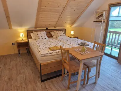 a bedroom with a bed and a table and chairs at Škedenj pri Vili Trate in Križevci pri Ljutomeru