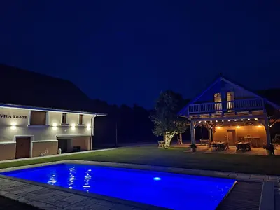 a house with a blue swimming pool at night at Škedenj pri Vili Trate in Križevci pri Ljutomeru