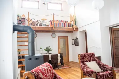 a living room with a fireplace and a table and chairs at Rustic House in Vipava Valley