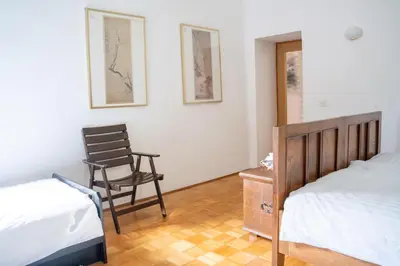 a bedroom with two beds and a chair in it at Rustic House in Vipava Valley