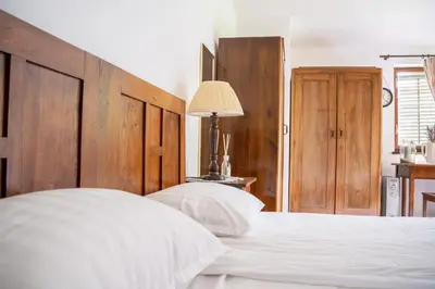 a bedroom with a large white bed with a wooden headboard at Rustic House in Vipava Valley