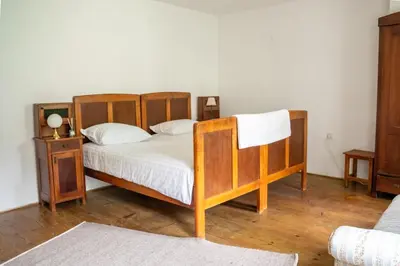 a bedroom with a wooden bed with white sheets at Rustic House in Vipava Valley