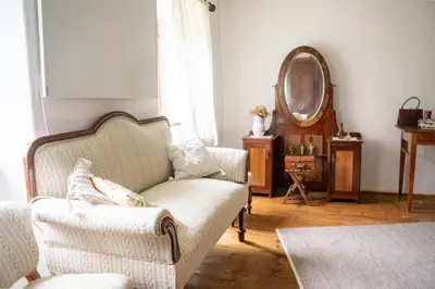 a living room with a couch and a mirror at Rustic House in Vipava Valley