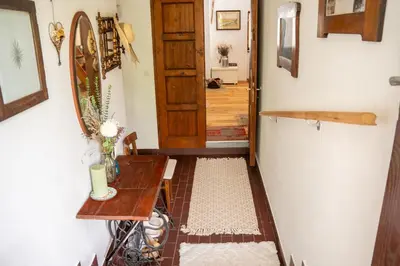 a hallway with a table and a wooden door at Rustic House in Vipava Valley