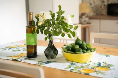 a table with a bottle of wine and a bowl of flowers at Rustic House in Vipava Valley