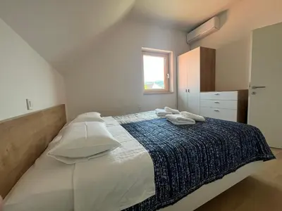 a bedroom with a large bed with towels on it at APARTMA BUQEZ-HOUSE 79 with Termal Riviera Čatež tickets in Čatež ob Savi