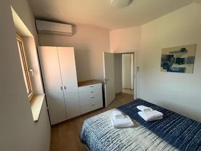 a bedroom with a bed with two towels on it at APARTMA BUQEZ-HOUSE 79 with Termal Riviera Čatež tickets in Čatež ob Savi