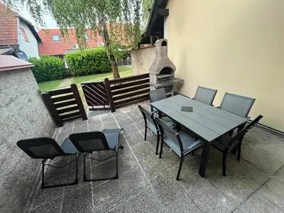 a patio with a table and chairs and a fireplace at APARTMA BUQEZ-HOUSE 79 with Termal Riviera Čatež tickets in Čatež ob Savi