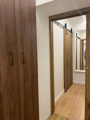 a room with wooden cabinets and a sliding door at Kolodvor 1870 - Old Town Apartment Kranj in Kranj